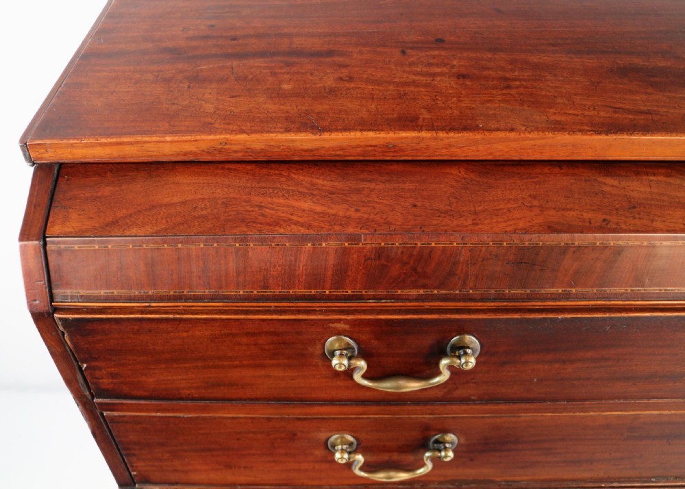 A George III mahogany secretaire low press cupboard featuring flame mahogany veneer panels, brass swan-neck handles, and bracket feet. View X