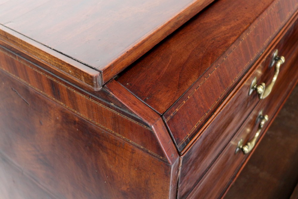 A George III mahogany secretaire low press cupboard featuring flame mahogany veneer panels, brass swan-neck handles, and bracket feet. View XI