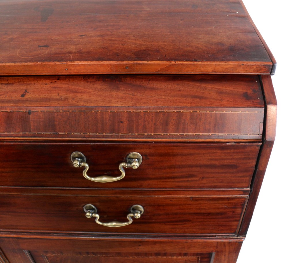 A George III mahogany secretaire low press cupboard featuring flame mahogany veneer panels, brass swan-neck handles, and bracket feet. View XII