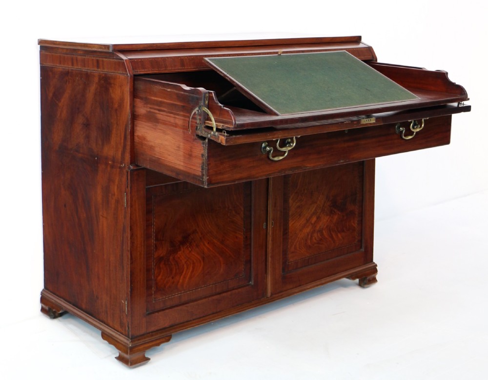 A George III mahogany secretaire low press cupboard featuring flame mahogany veneer panels, brass swan-neck handles, and bracket feet. View XIII