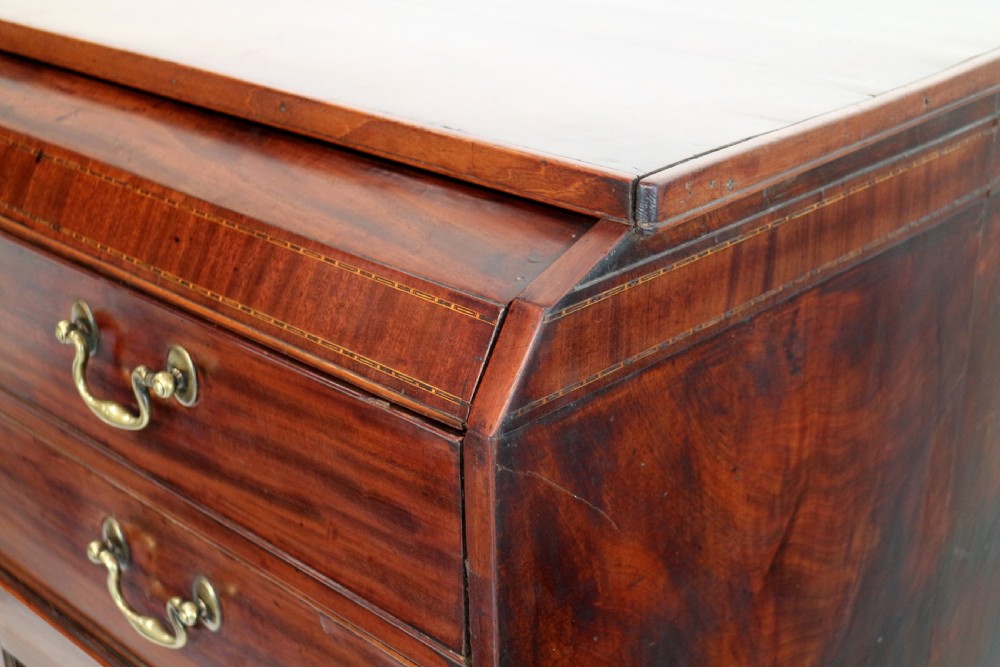 A George III mahogany secretaire low press cupboard featuring flame mahogany veneer panels, brass swan-neck handles, and bracket feet. View XIV