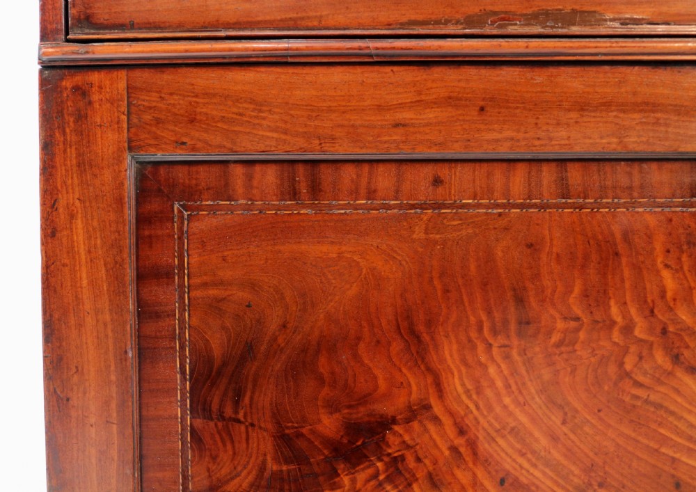 A George III mahogany secretaire low press cupboard featuring flame mahogany veneer panels, brass swan-neck handles, and bracket feet. View XVI