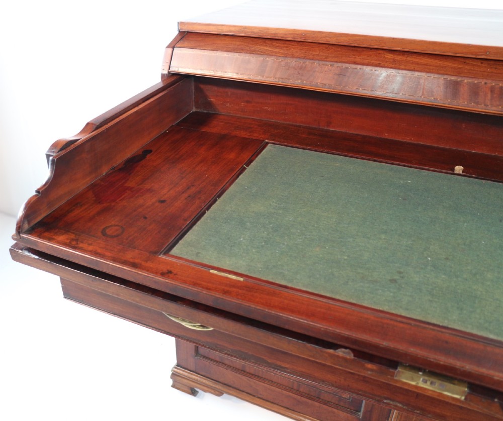 A George III mahogany secretaire low press cupboard featuring flame mahogany veneer panels, brass swan-neck handles, and bracket feet. View XVII