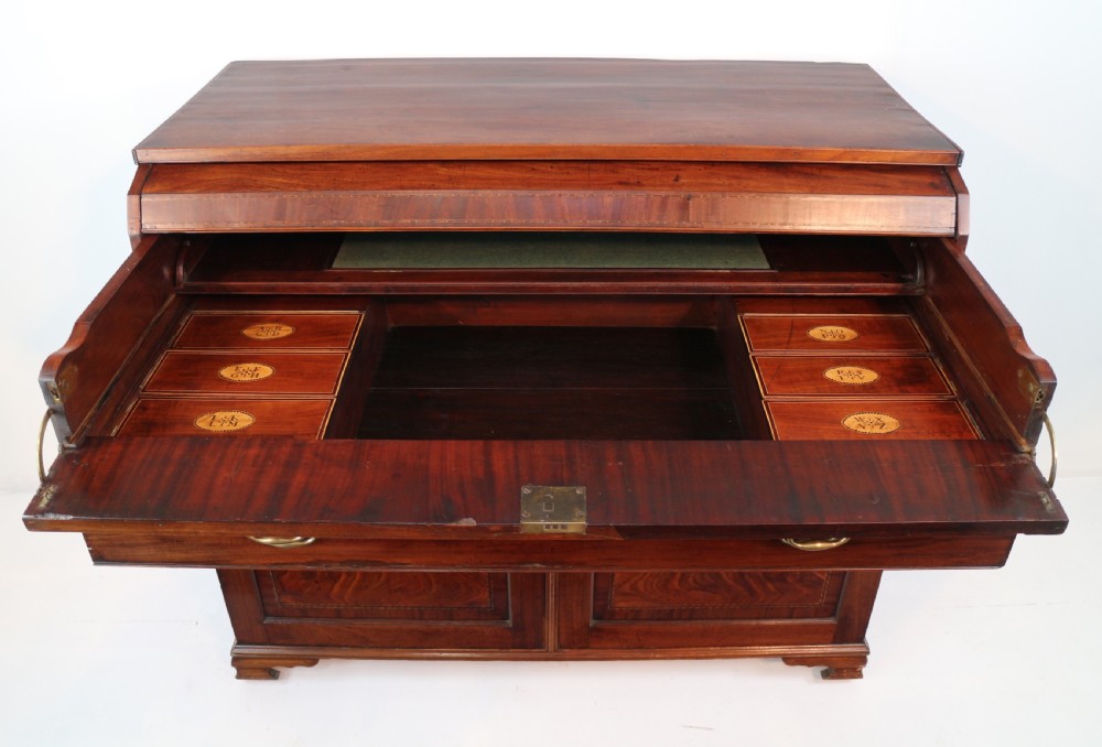 A George III mahogany secretaire low press cupboard featuring flame mahogany veneer panels, brass swan-neck handles, and bracket feet. View XXII