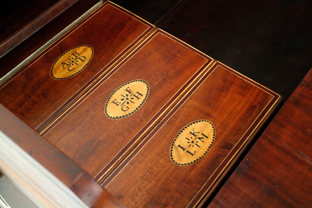 A George III mahogany secretaire low press cupboard featuring flame mahogany veneer panels, brass swan-neck handles, and bracket feet. View XXIII