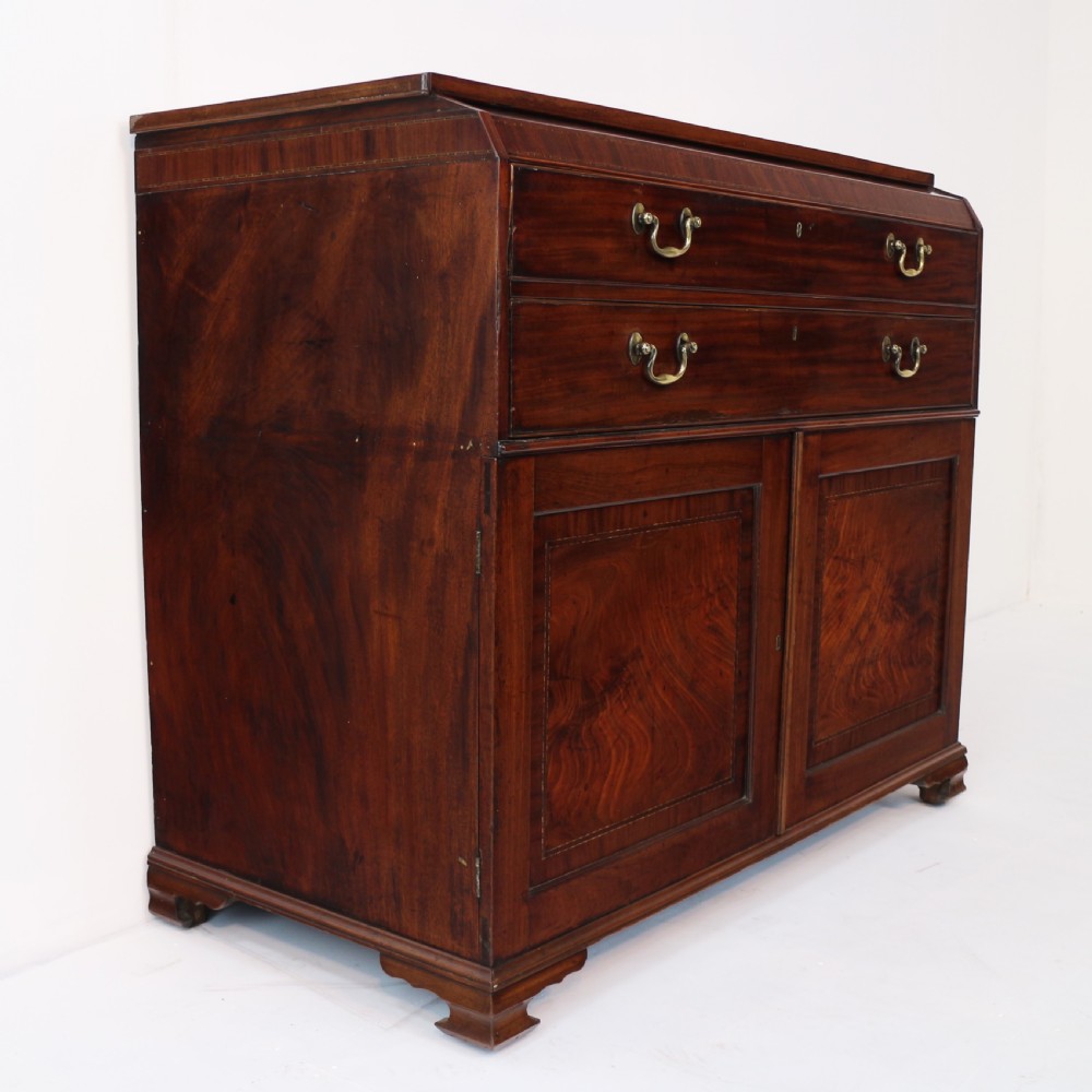 A George III mahogany secretaire low press cupboard featuring flame mahogany veneer panels, brass swan-neck handles, and bracket feet. View XXVIII