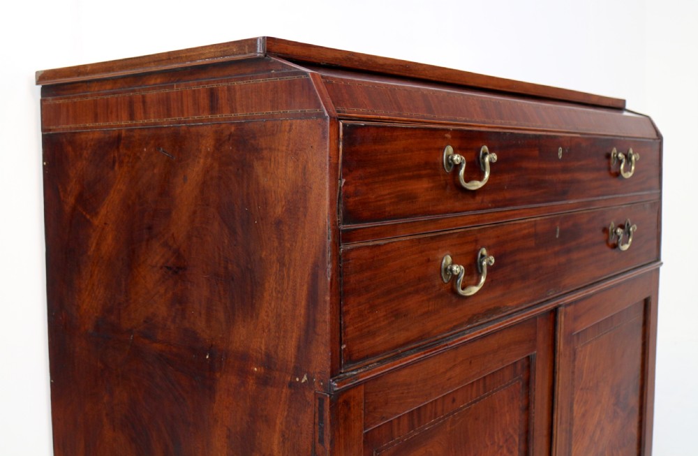 A George III mahogany secretaire low press cupboard featuring flame mahogany veneer panels, brass swan-neck handles, and bracket feet. View XXIX