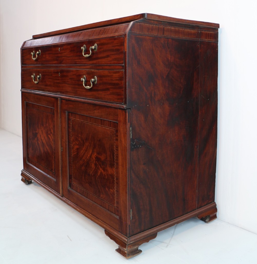 A George III mahogany secretaire low press cupboard featuring flame mahogany veneer panels, brass swan-neck handles, and bracket feet. View XXXI