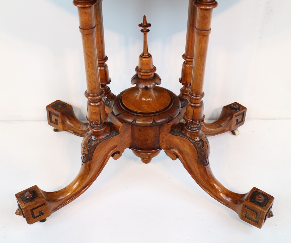 A Victorian burr walnut demilune card table featuring floral marquetry inlays, turned twin-column supports, and a carved central finial on quadruped legs. View VII