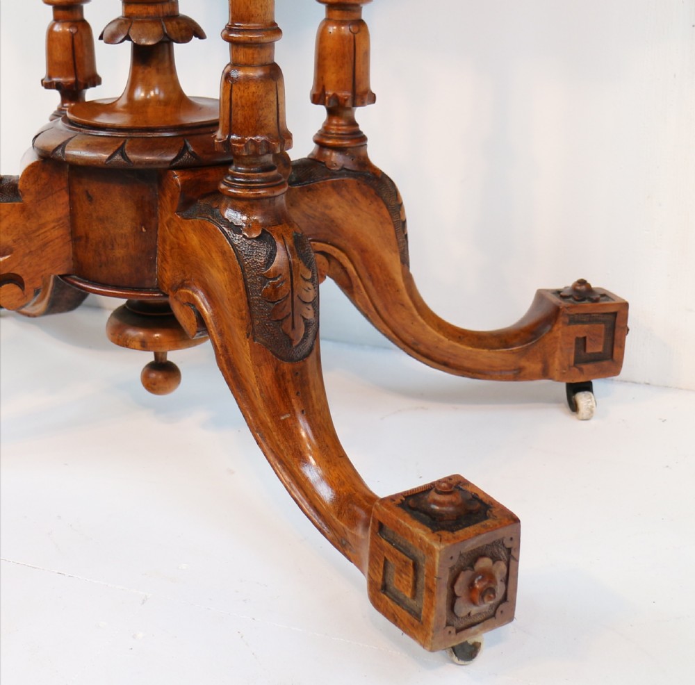 A Victorian burr walnut demilune card table featuring floral marquetry inlays, turned twin-column supports, and a carved central finial on quadruped legs. View VIII