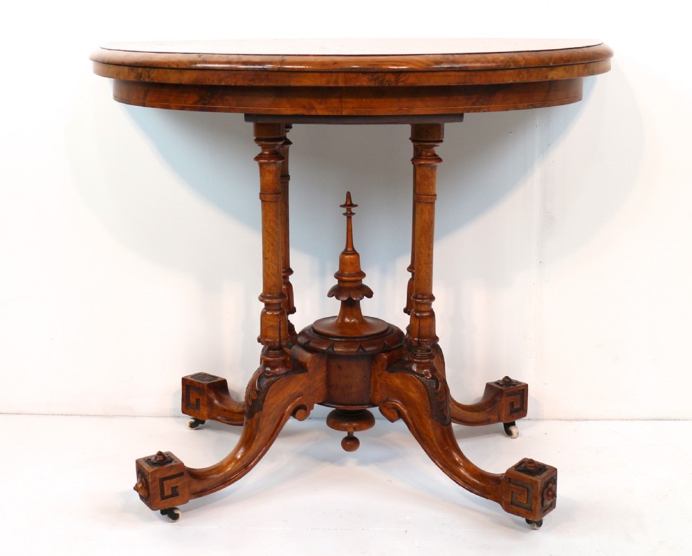 A Victorian burr walnut demilune card table featuring floral marquetry inlays, turned twin-column supports, and a carved central finial on quadruped legs. View IX