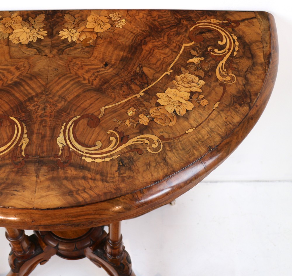 A Victorian burr walnut demilune card table featuring floral marquetry inlays, turned twin-column supports, and a carved central finial on quadruped legs. View XIII