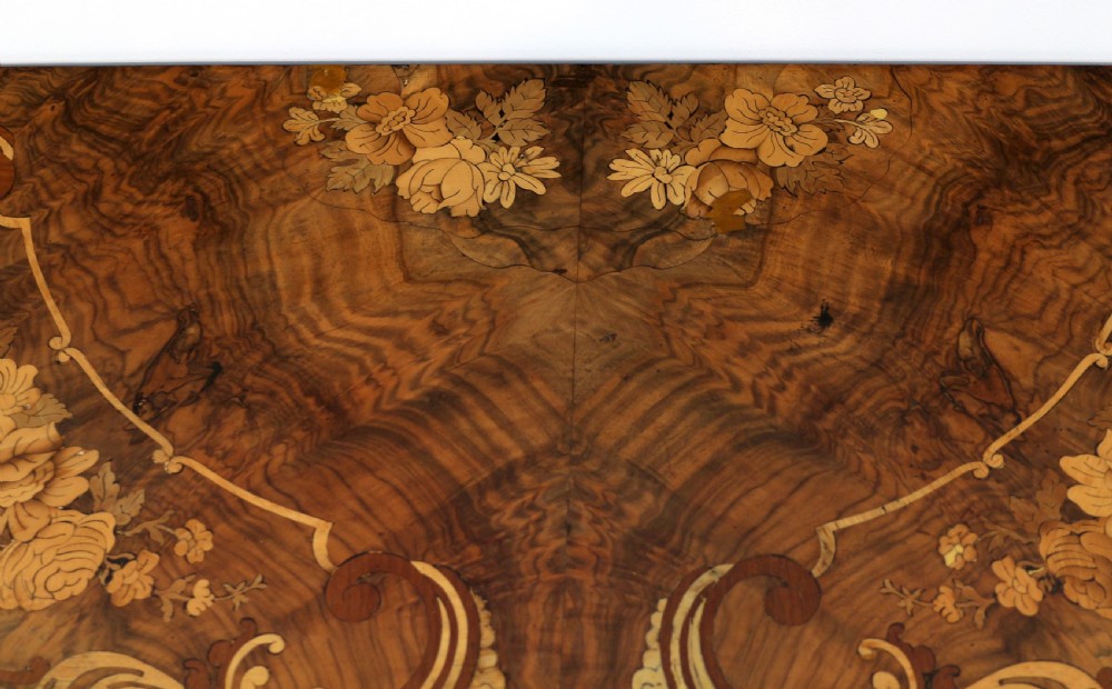 A Victorian burr walnut demilune card table featuring floral marquetry inlays, turned twin-column supports, and a carved central finial on quadruped legs. View XIV