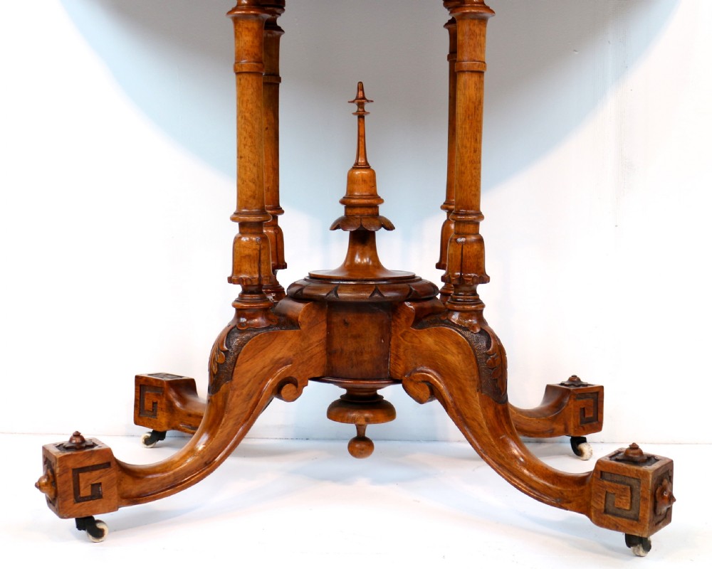 A Victorian burr walnut demilune card table featuring floral marquetry inlays, turned twin-column supports, and a carved central finial on quadruped legs. View XX