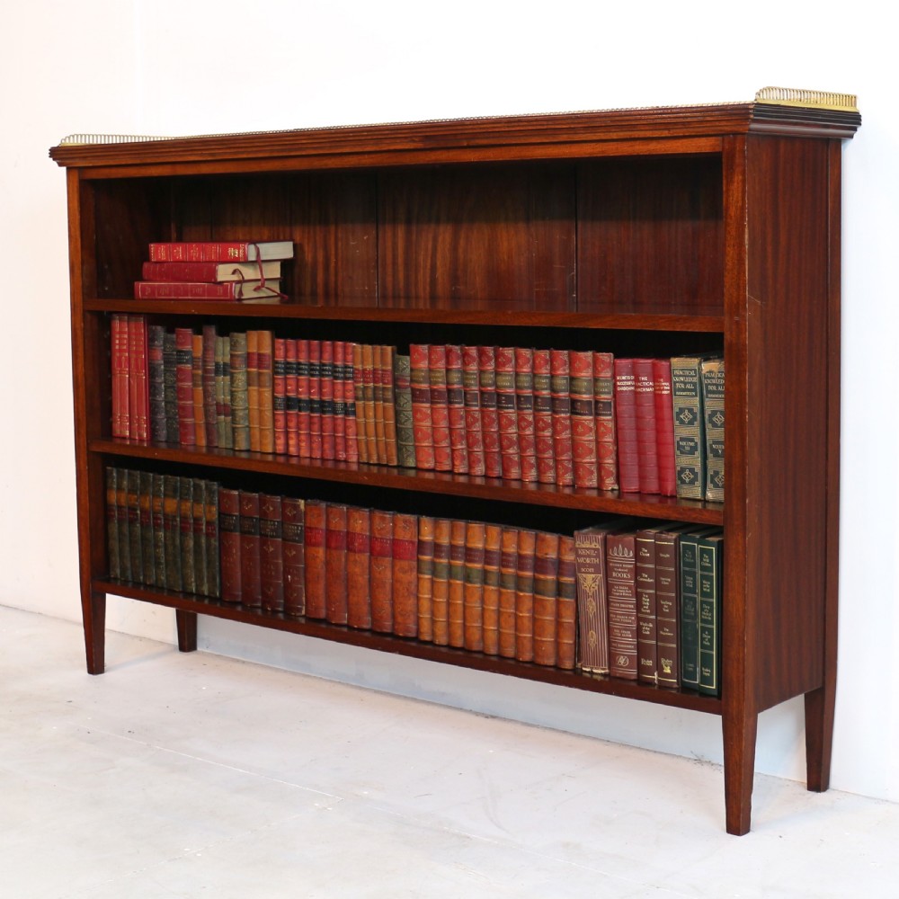 A Victorian walnut open bookcase featuring three horizontal shelves and a decorative brass gallery rail along the top edge. View XXII