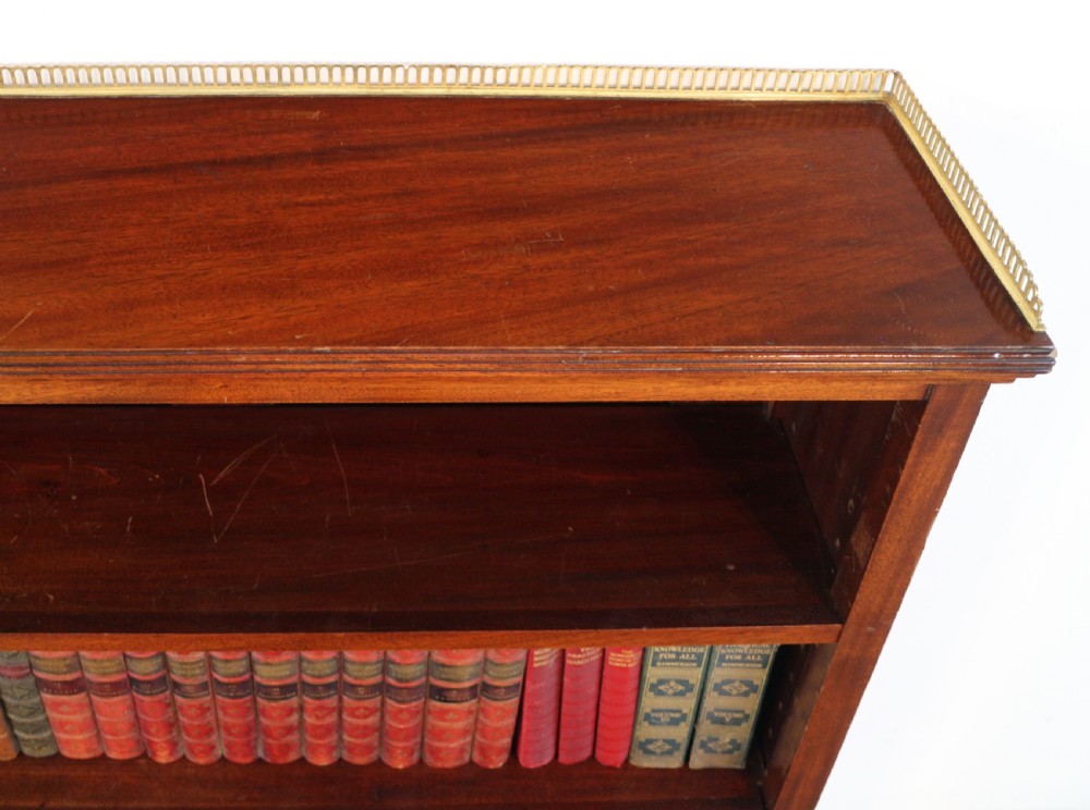 A Victorian walnut open bookcase featuring three horizontal shelves and a decorative brass gallery rail along the top edge. View II