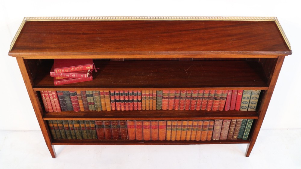 A Victorian walnut open bookcase featuring three horizontal shelves and a decorative brass gallery rail along the top edge. View III