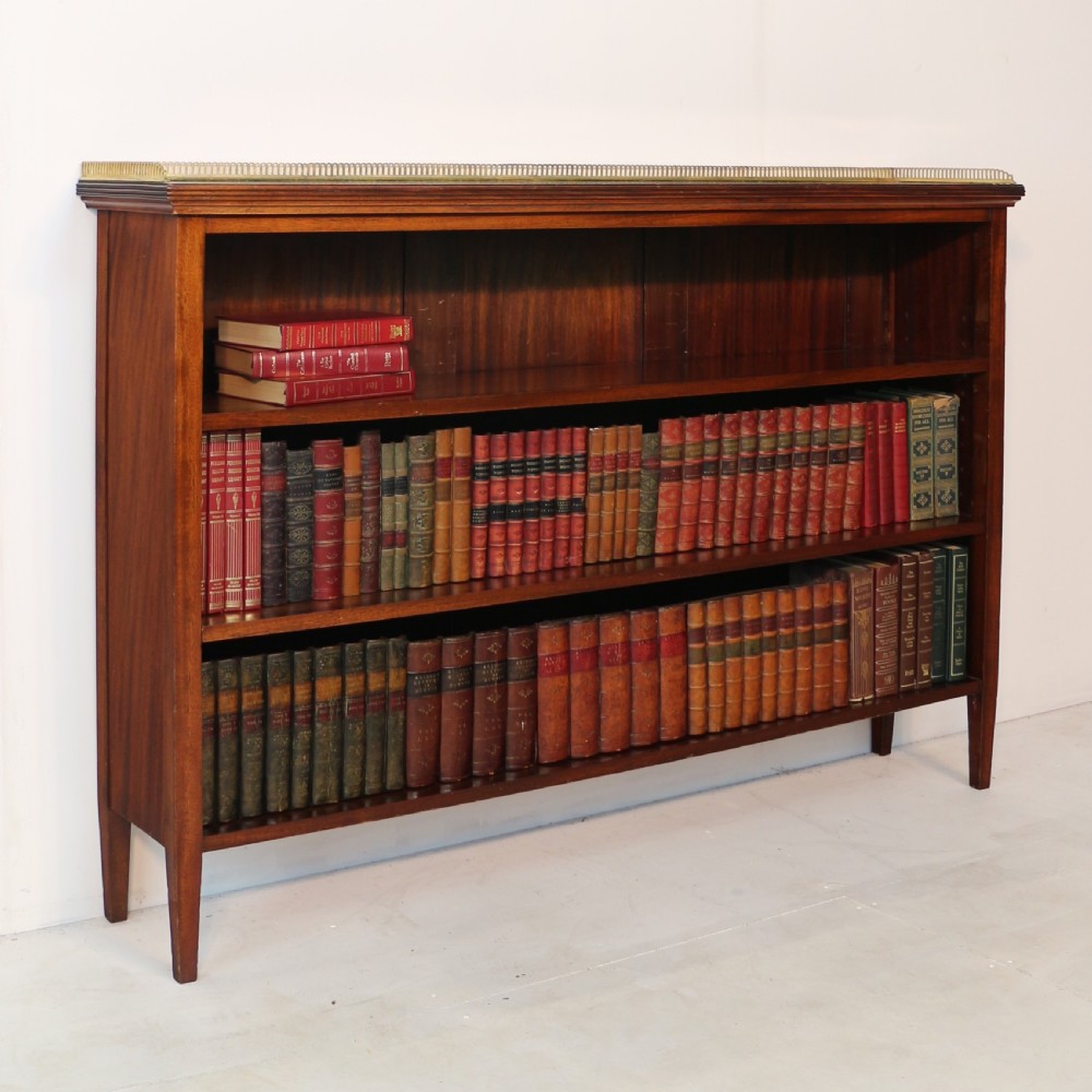 A Victorian walnut open bookcase featuring three horizontal shelves and a decorative brass gallery rail along the top edge. View V