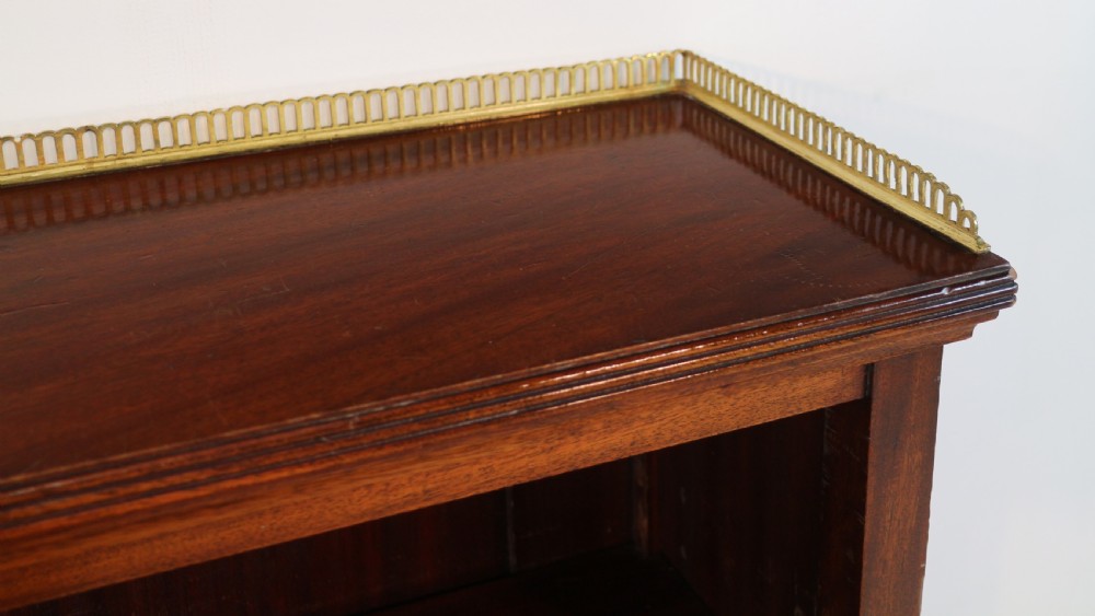 A Victorian walnut open bookcase featuring three horizontal shelves and a decorative brass gallery rail along the top edge. View X