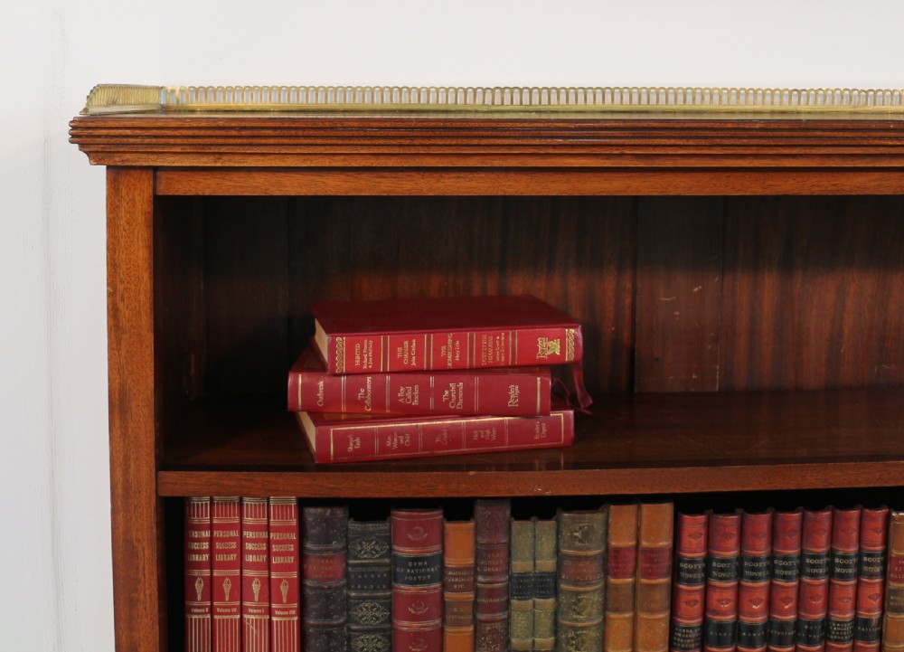A Victorian walnut open bookcase featuring three horizontal shelves and a decorative brass gallery rail along the top edge. View XII