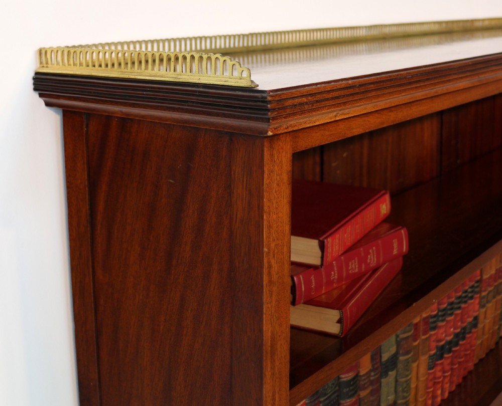 A Victorian walnut open bookcase featuring three horizontal shelves and a decorative brass gallery rail along the top edge. View XVII