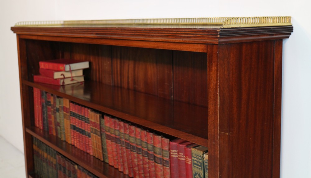 A Victorian walnut open bookcase featuring three horizontal shelves and a decorative brass gallery rail along the top edge. View XX