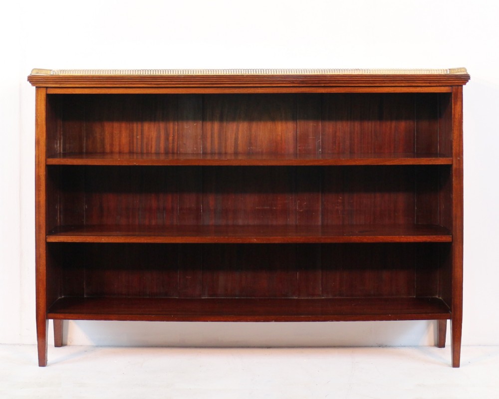 A Victorian walnut open bookcase featuring three horizontal shelves and a decorative brass gallery rail along the top edge.