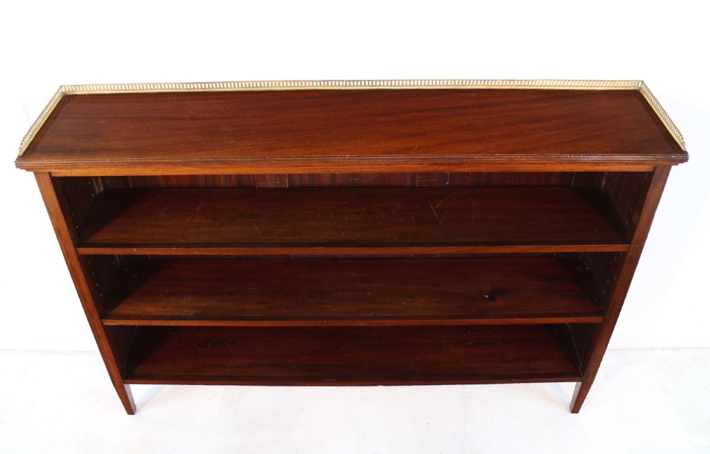 A Victorian walnut open bookcase featuring three horizontal shelves and a decorative brass gallery rail along the top edge. View XXIII