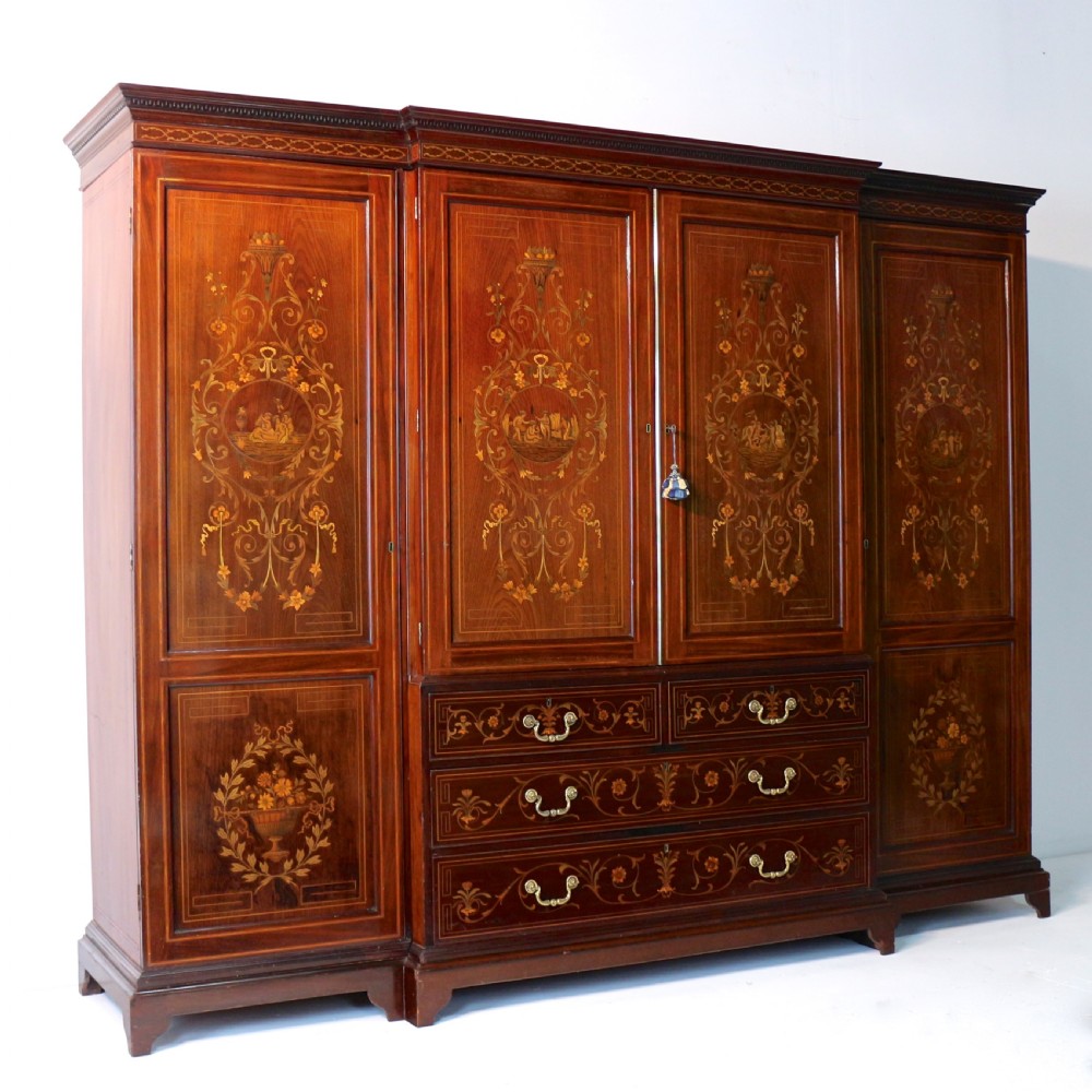 A large Victorian mahogany breakfront wardrobe with intricate floral marquetry inlays on the panel doors and lower drawer fronts. View V