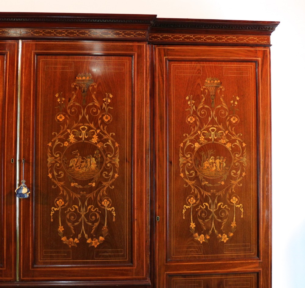 A large Victorian mahogany breakfront wardrobe with intricate floral marquetry inlays on the panel doors and lower drawer fronts. View VI