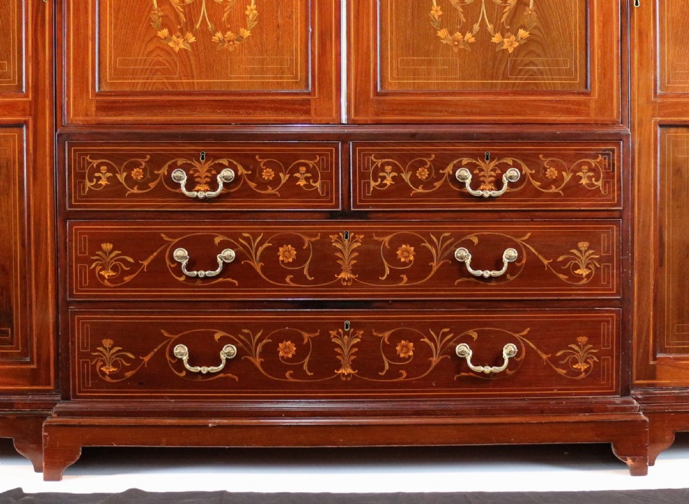 A large Victorian mahogany breakfront wardrobe with intricate floral marquetry inlays on the panel doors and lower drawer fronts. View VII