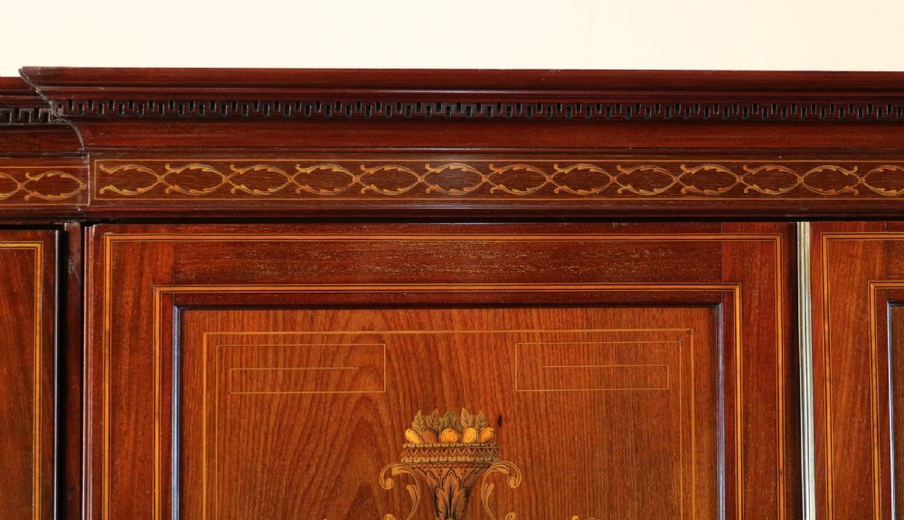 A large Victorian mahogany breakfront wardrobe with intricate floral marquetry inlays on the panel doors and lower drawer fronts. View XVI
