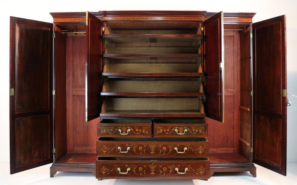 A large Victorian mahogany breakfront wardrobe with intricate floral marquetry inlays on the panel doors and lower drawer fronts. View XIX