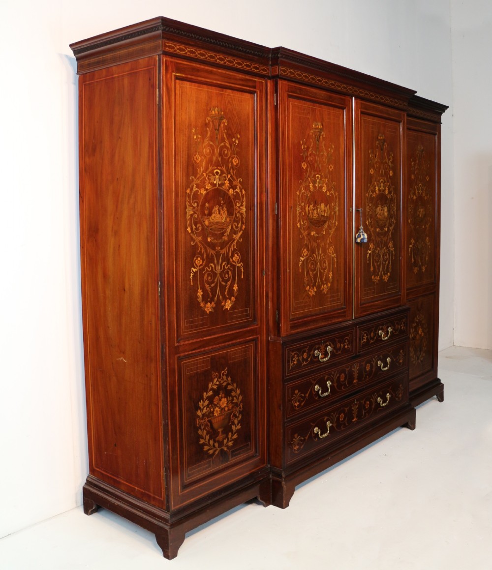 A large Victorian mahogany breakfront wardrobe with intricate floral marquetry inlays on the panel doors and lower drawer fronts. View XXVI