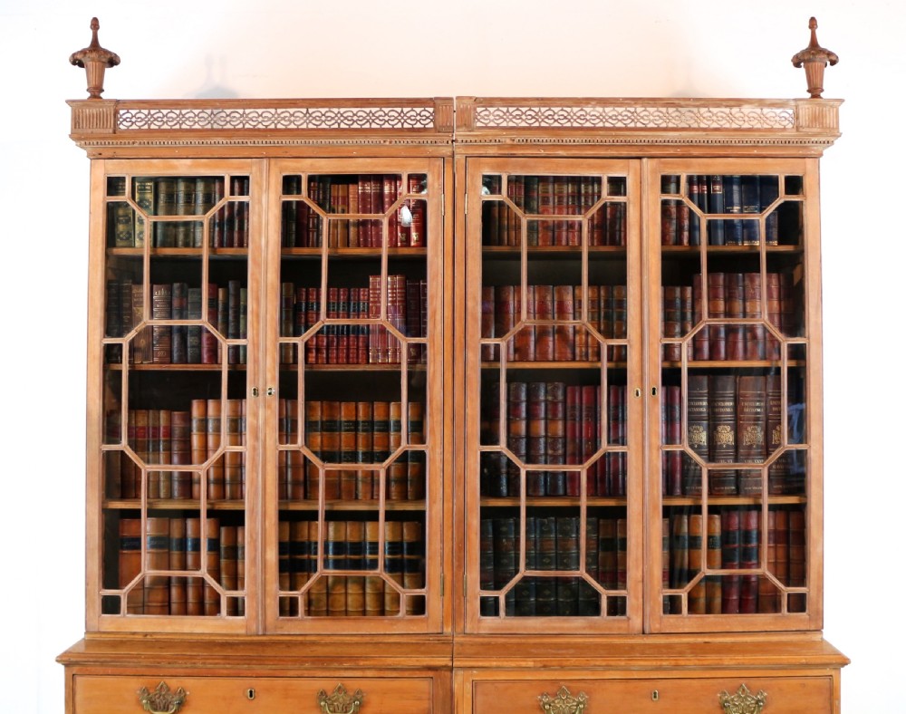 A large George III Chippendale period double bookcase crafted in natural pine, featuring astragal glazed upper doors topped with urn finials and lower panelled cupboards. View III