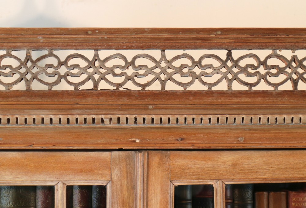 A large George III Chippendale period double bookcase crafted in natural pine, featuring astragal glazed upper doors topped with urn finials and lower panelled cupboards. View XIII