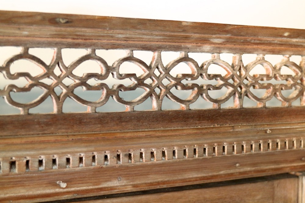 A large George III Chippendale period double bookcase crafted in natural pine, featuring astragal glazed upper doors topped with urn finials and lower panelled cupboards. View XIV