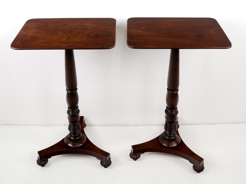 A pair of mahogany Regency wine tables featuring rounded rectangular tops, central turned pedestal columns, and tri-form bases resting on carved feet. View VI