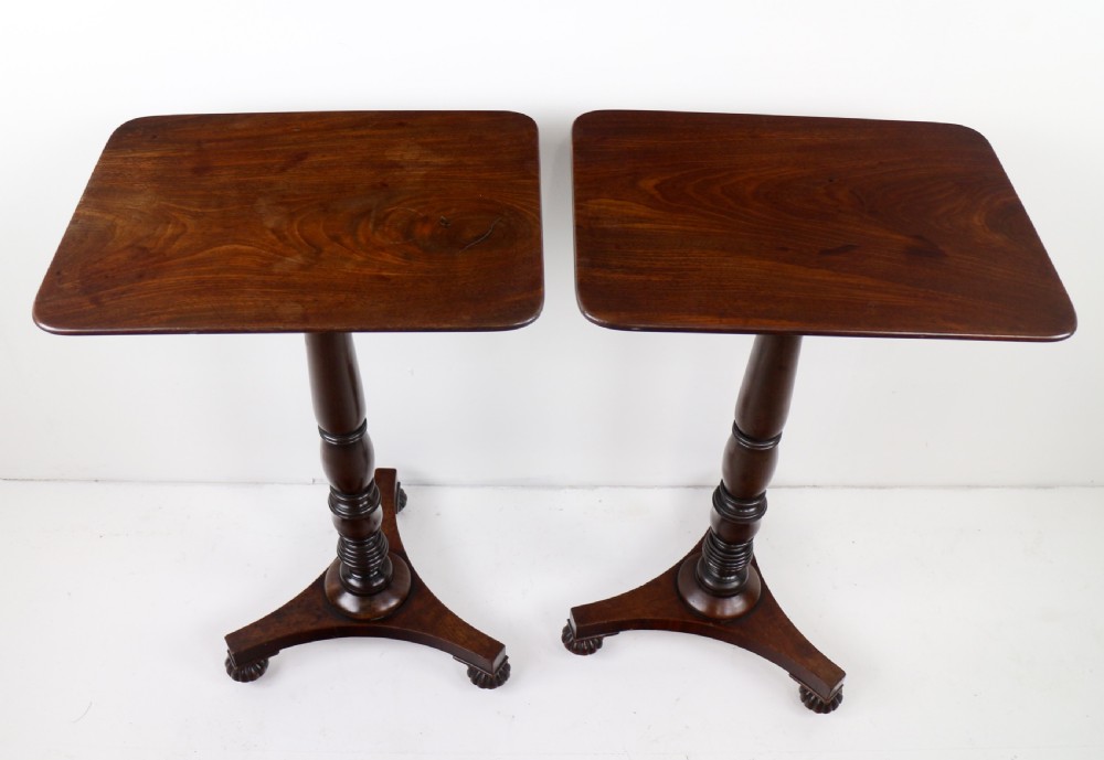 A pair of mahogany Regency wine tables featuring rounded rectangular tops, central turned pedestal columns, and tri-form bases resting on carved feet. View VII