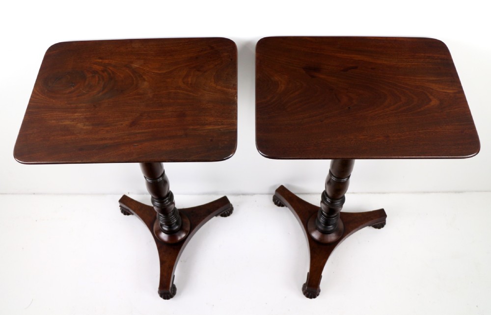A pair of mahogany Regency wine tables featuring rounded rectangular tops, central turned pedestal columns, and tri-form bases resting on carved feet. View VIII