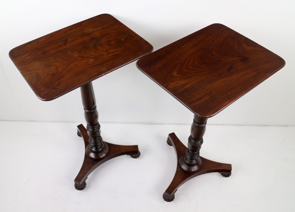 A pair of mahogany Regency wine tables featuring rounded rectangular tops, central turned pedestal columns, and tri-form bases resting on carved feet. View IX