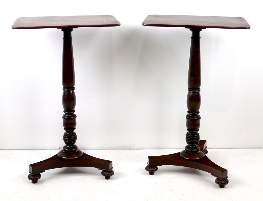 A pair of mahogany Regency wine tables featuring rounded rectangular tops, central turned pedestal columns, and tri-form bases resting on carved feet. View XI