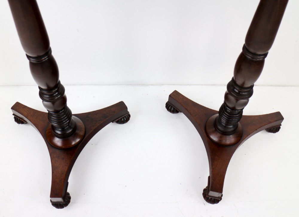 A pair of mahogany Regency wine tables featuring rounded rectangular tops, central turned pedestal columns, and tri-form bases resting on carved feet. View XIII