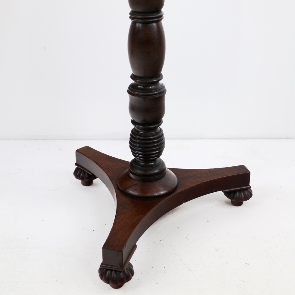 A pair of mahogany Regency wine tables featuring rounded rectangular tops, central turned pedestal columns, and tri-form bases resting on carved feet. View XVII