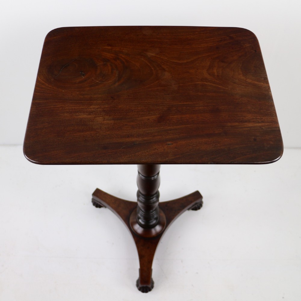 A pair of mahogany Regency wine tables featuring rounded rectangular tops, central turned pedestal columns, and tri-form bases resting on carved feet. View XX