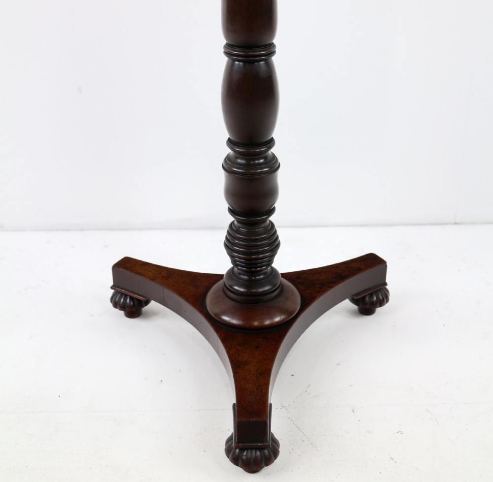 A pair of mahogany Regency wine tables featuring rounded rectangular tops, central turned pedestal columns, and tri-form bases resting on carved feet. View XXII