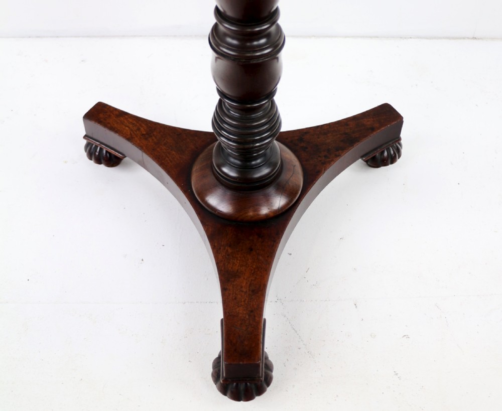 A pair of mahogany Regency wine tables featuring rounded rectangular tops, central turned pedestal columns, and tri-form bases resting on carved feet. View XXIII