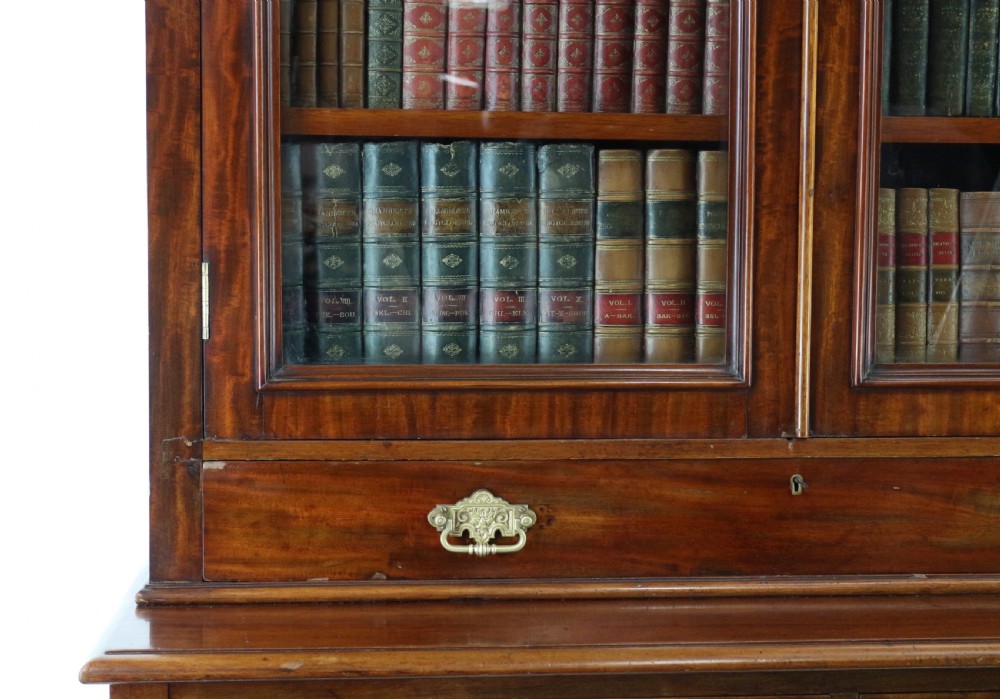 An early Victorian mahogany bookcase featuring an upper glazed section with two arched doors and a lower cupboard base with two drawers. View XI