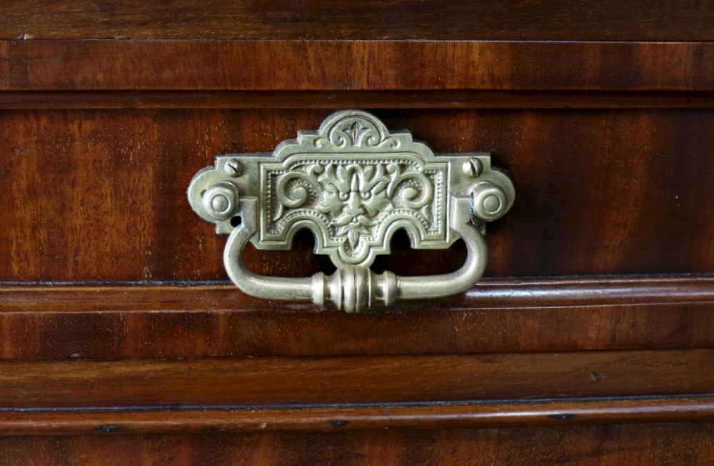 An early Victorian mahogany bookcase featuring an upper glazed section with two arched doors and a lower cupboard base with two drawers. View XVII