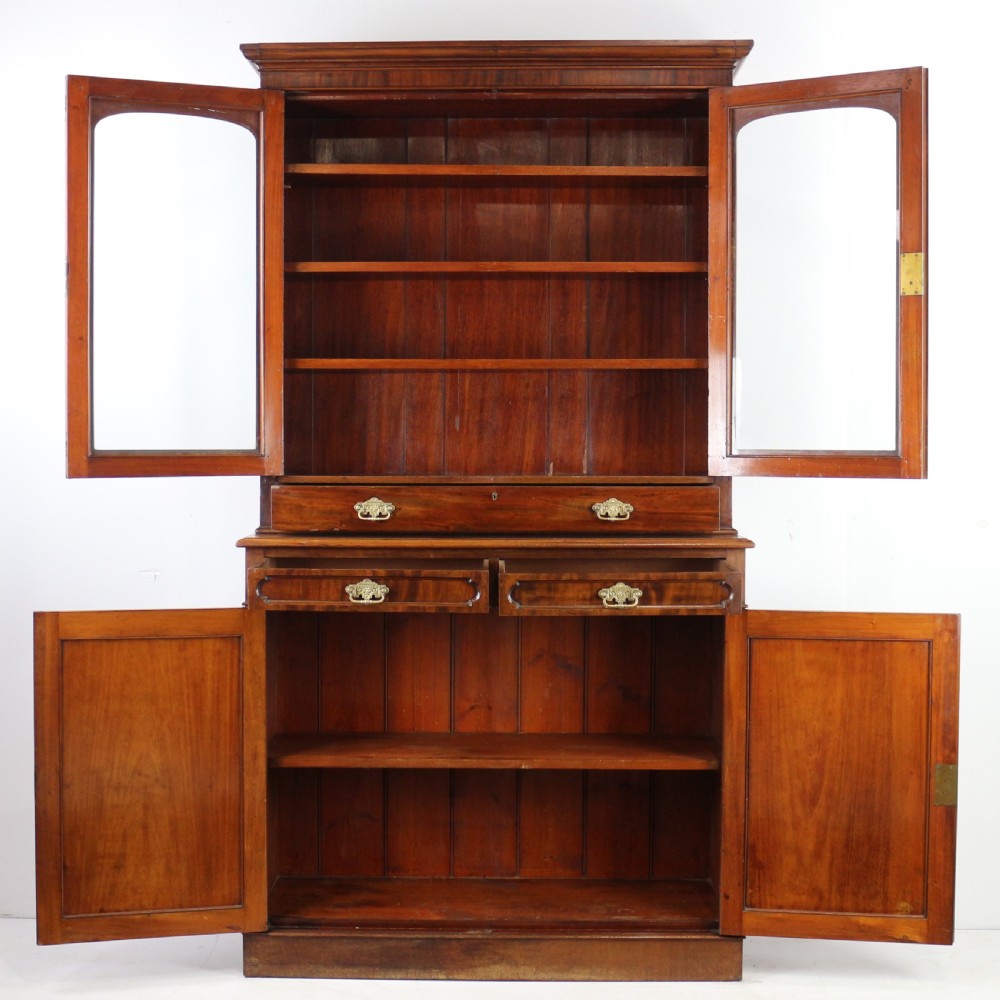 An early Victorian mahogany bookcase featuring an upper glazed section with two arched doors and a lower cupboard base with two drawers. View XXIII